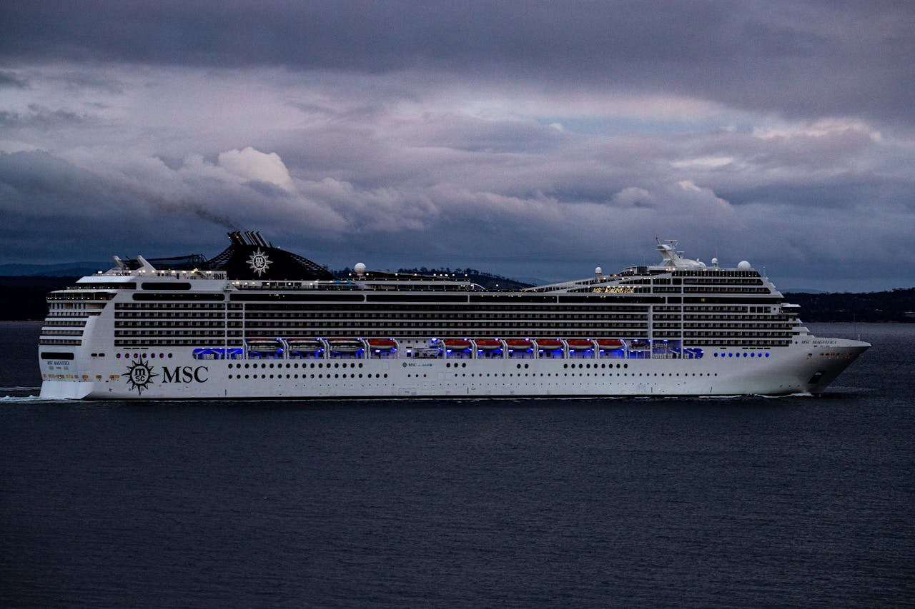 MSC cruise ship navigating waters near Hobart, Tasmania against a dramatic cloudy sky.